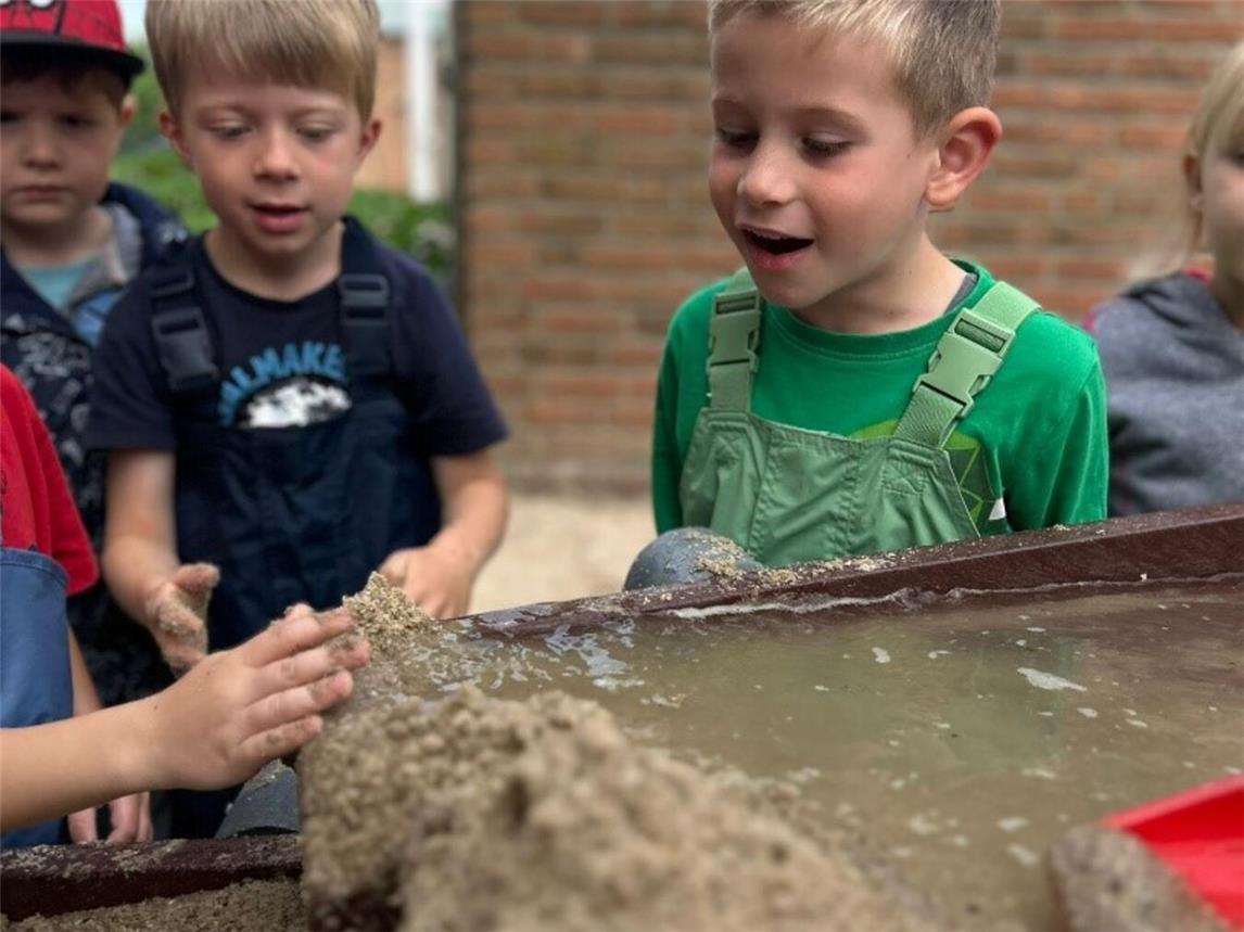 Sand wurde auf die Bahn geschaufelt und dann hieß es „Wasser marsch“ von den Kindern und das Matschen konnte losgehen. Foto: Kindergarten St. Stephanus