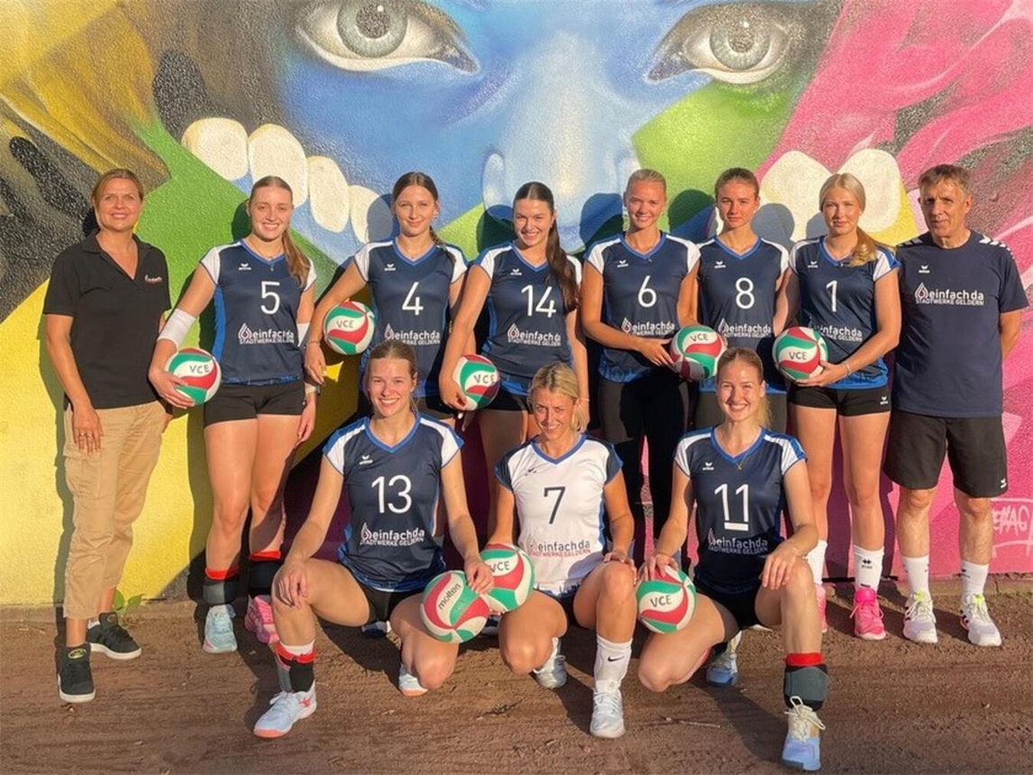 Sarah Bousart von den Stadtwerken Geldern (links) übergibt die neuen Trikots an das Team des VCE sowie ihren Co-Trainer „Ille“ van Meegen (r.). Foto: VCE Geldern