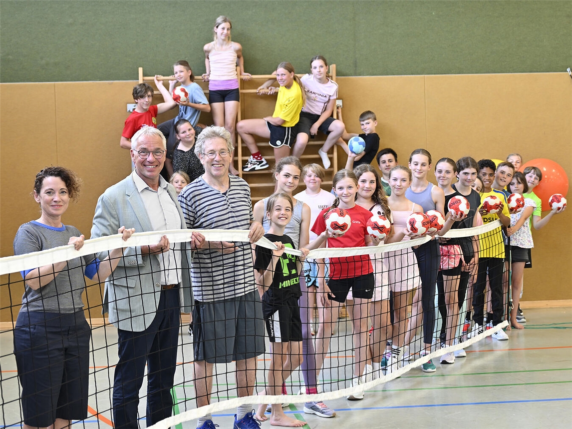 "Schüler und Lehrer erhalten Sportmaterialien von Voba-Leiter Steenmans, Schulleiterin Sommerfeldt und Sportlehrer van Wijnen"