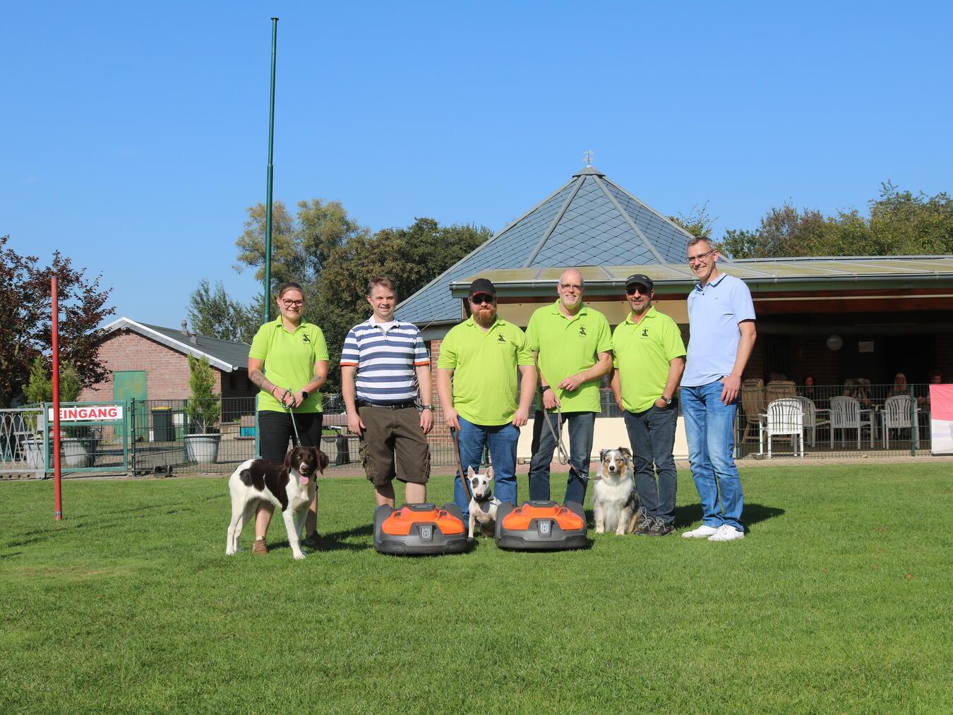 Sie freuen sich über die Arbeitserleichterung durch die fleißigen Mähroboter, v.l.: Lysanne Hanings, 2. Vorsitzende des Hundevereins GHSV Weeze, von der Stiftung „Jetzt Weeze“ Dominik Behet, der 1. Vorsitzende des GHSV Weeze Lars Feddema sowie Kassierer Jochen Helpenstein und Obmann Klaus Neffelt mit Konrad Willemsen von der Stiftung. Foto: privat
