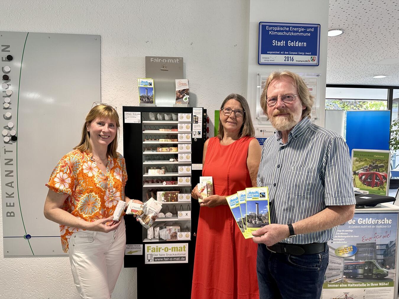 Sie präsentieren den „Fair-o-maten“ im Gelderner Rathaus (v.l.n.r.): Doris Schreurs (Stadt Geldern), Vera van de Loo & Karl-Heinz Pasing (beide Gelderner Fairtrade-Steuerungsgruppe).Foto: Stadt Geldern/Terhorst