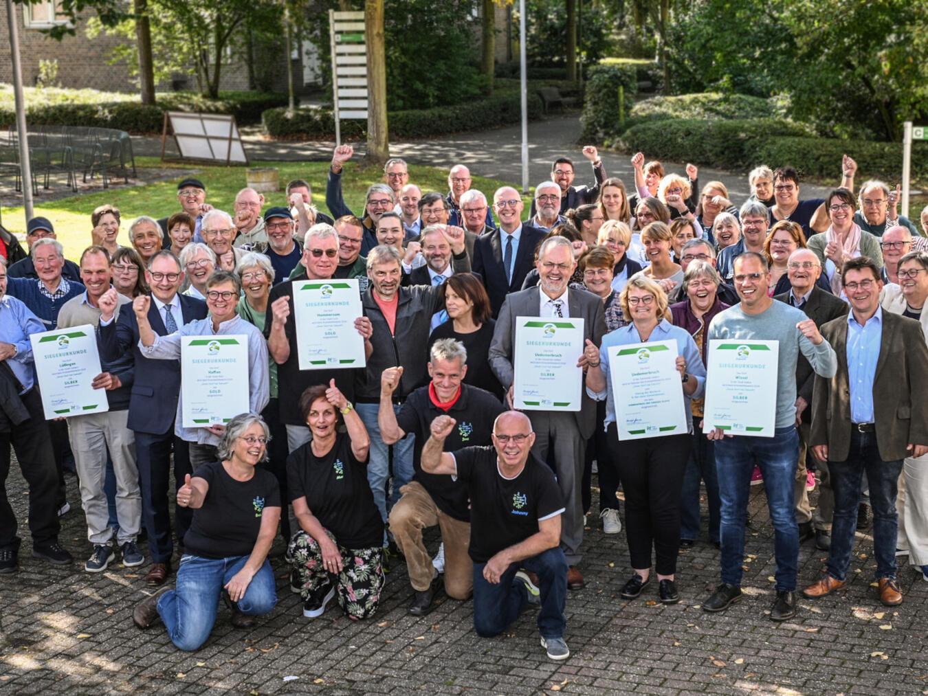 Hommersum und Haffen sind die neuen „Golddörfer“ So sehen Sieger aus: Landrat Christoph Gerwers (Bildmitte) zeichnete beim Kreiswettbewerb „Unser Dorf hat Zukunft“ die Gold- und Silberdörfer aus. Foto: Kreis Kleve/Markus van Offern