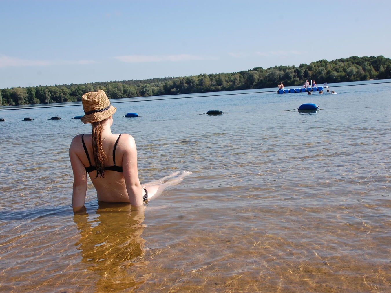 Sommerferien mit Urlaubsgefühl am See Sonnenbaden am Sandstrand und eine Abkühlung im Wasser, runden einen perfekten Sommertag ab.