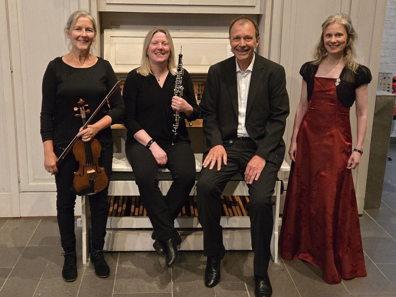 "Sopranistin Maria Klier mit Musikerensemble bei Konzertauftritt, Orgel, Violine und Oboe, klassische Musikdarbietung."