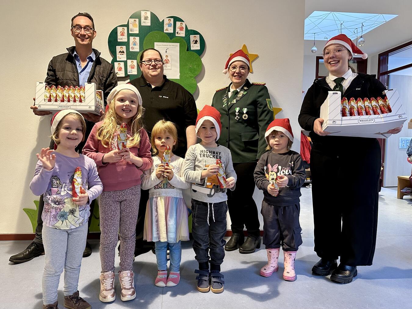 SOS-Bereichsleiter Detmar Pommering (hinten links) freut sich gemeinsam mit den Kindern der InKita- in Kleve über die Nikolaus-Spende der Bezirksjungschützenmeisterin Emilie van Afferden (vorne rechts), begleitet von Natalie van Afferden (2.v.r.) und Sabrina Flintrop. Foto: SOS-Kinderdorf Niederrhein / Katrin Wißen