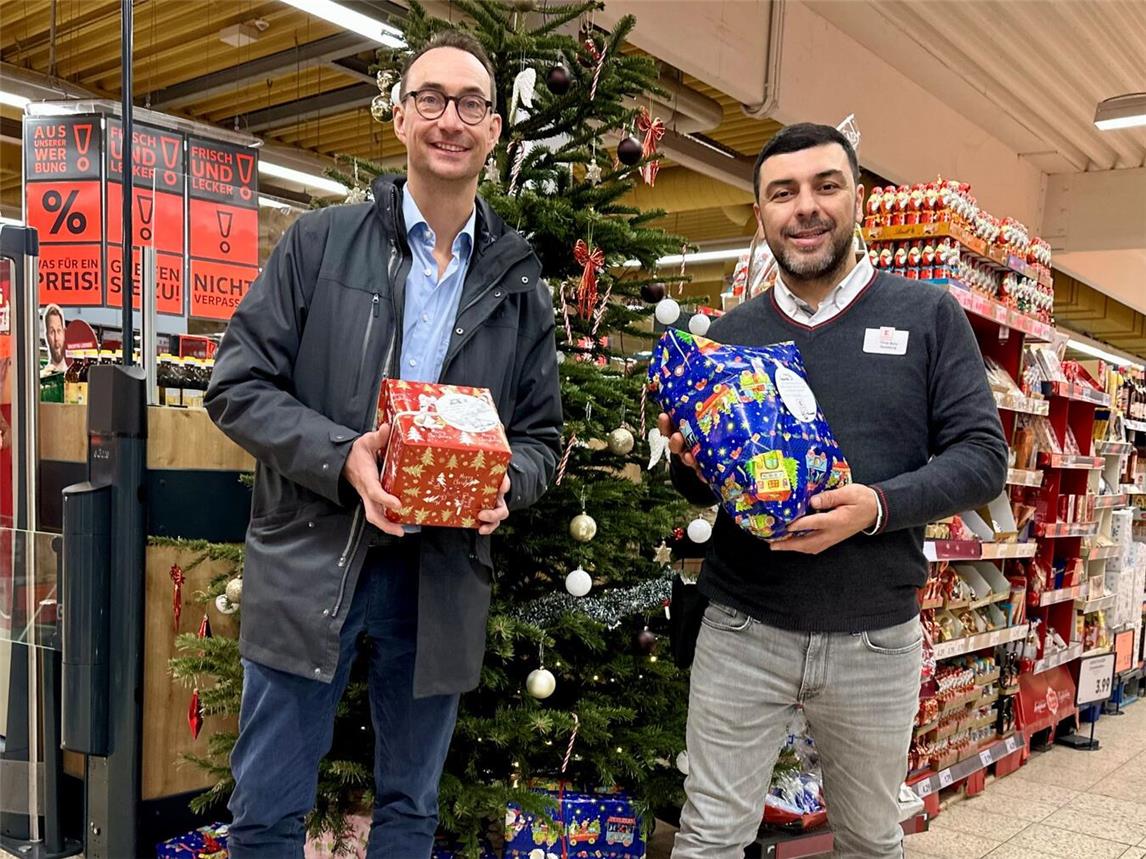 SOS-Bereichsleiter Detmar Pommering nimmt die Geschenke der Wunschbaumaktion von Kaufland-Hausleiter Yilmaz Bartu gerne entgegen. Foto: SOS-Kinderdorf Niederrhein / Katrin Wißen