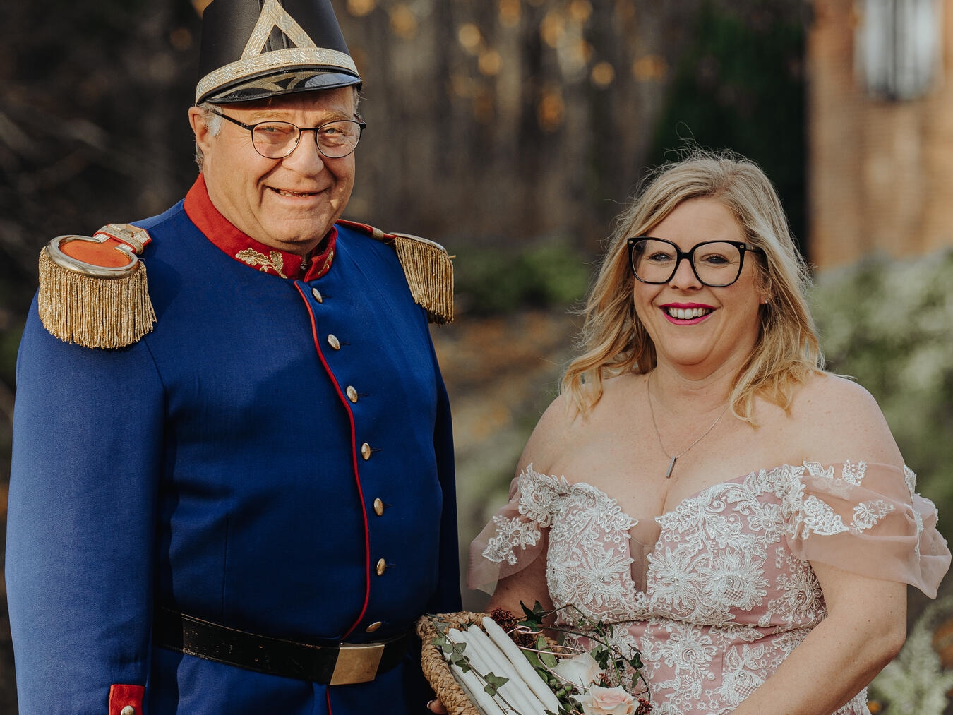 "Spargelprinzessin Monika II. und Spargelgrenadier Peter Strauß beim Fest der Spargelprinzessin, lächelnd mit Gästen."
