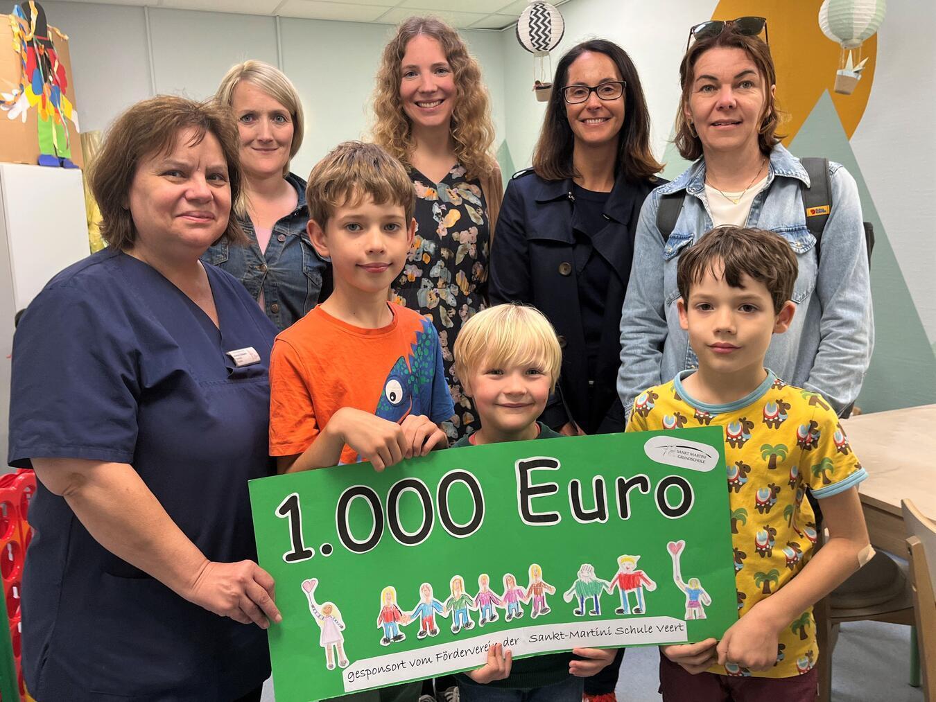 Spendenübergabe im Spielzimmer der Klinik für Kinder und Jugendliche des St.-Clemens-Hospitals Geldern (v. l.): Asimina Salapata, Oberärztin der Klinik, Rebecca de Vries mit Sohn Benedikt (vorne Mitte), Jan und Mutter Angelina Brinkmann, Daniela Claßen (Schulleiterin der Sankt-Martini-Schule), Lehrerin Nina Hegmans und Tim Brinkmann.Foto: Elwi/St.-Clemens-Hospital
