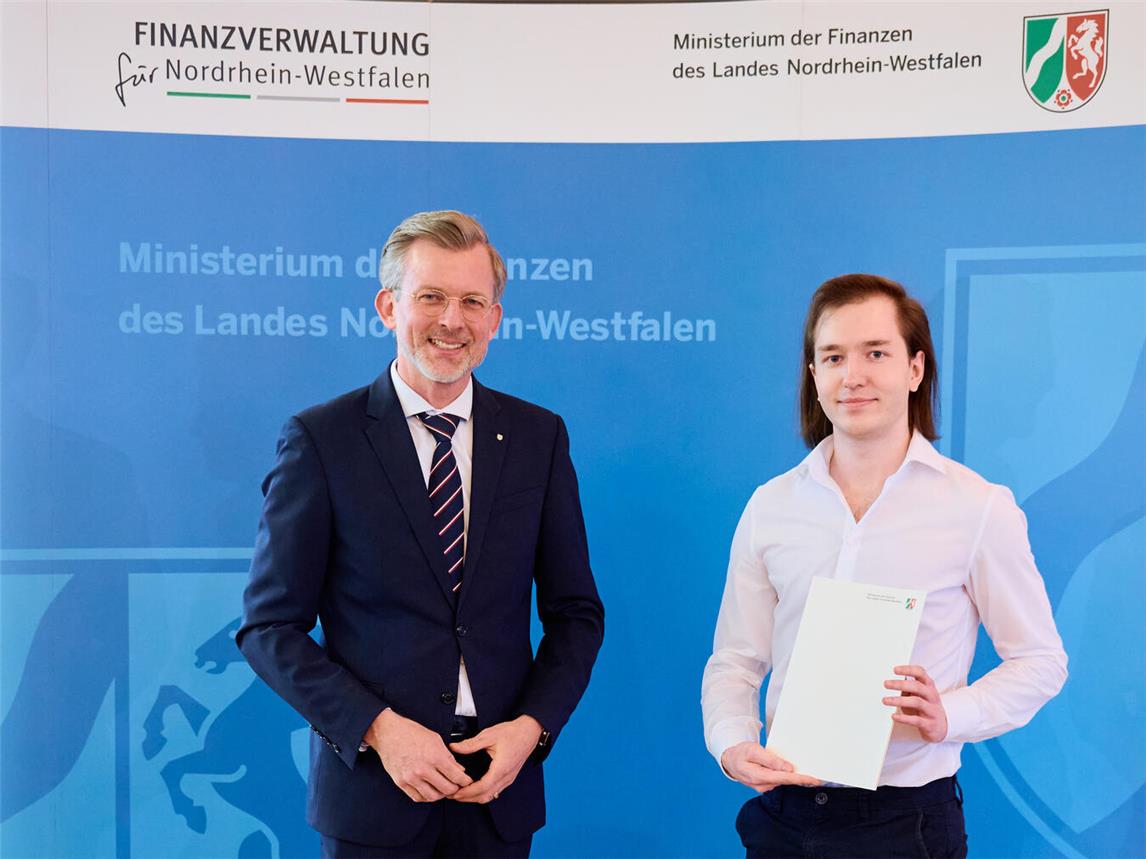 Staatssekretär Dr. Dirk Günnewig gratuliert Sem Lübeck zum erfolgreichen Absolvieren seiner Ausbildung. Foto: FM NRW Bernd Thissen