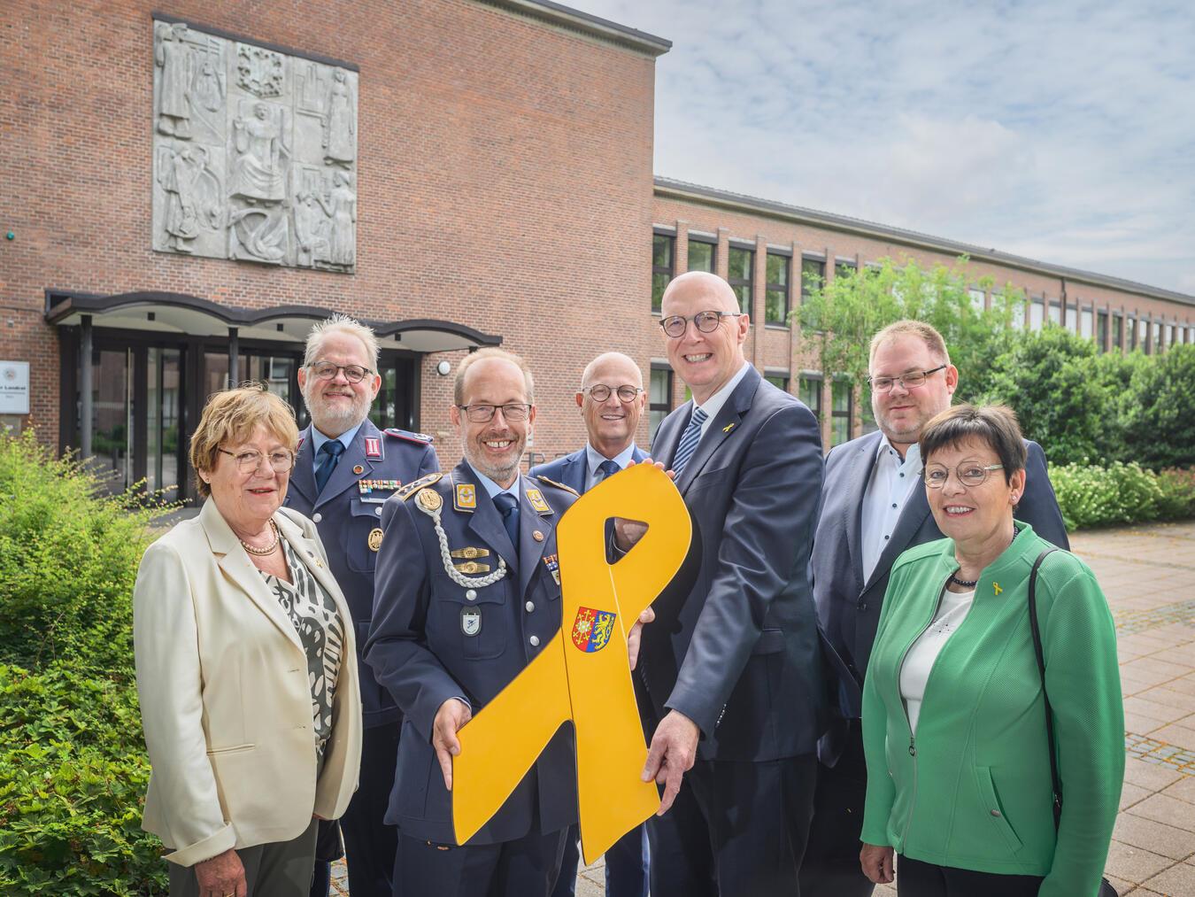 Stabsfeldwebel Volker Keil, Landesvorsitzender des Landesverbandes West des Deutschen Bundeswehr Verbandes (3. v. l.) überreichte am ersten Nationalen Veteranentag die „Gelbe Schleife“ an Landrat Christoph Gerwers (3.v. r.). Weitere Gäste waren (v. l.) Annded Peters (stellvertretende Gocher Bürgermeisterin), Oberstleutnant i.G. Falk Neutzer (Standortkameradschaft Kalkar/Uedem), Emmerichs Bürgermeister Peter Hinze, Carsten Naß (stellvertretender Kalkarer Bürgermeister) und Maria Ingenerf (stellvertretende Uedemer Bürgermeisterin). Foto: Kreis Kleve /Markus van Offern