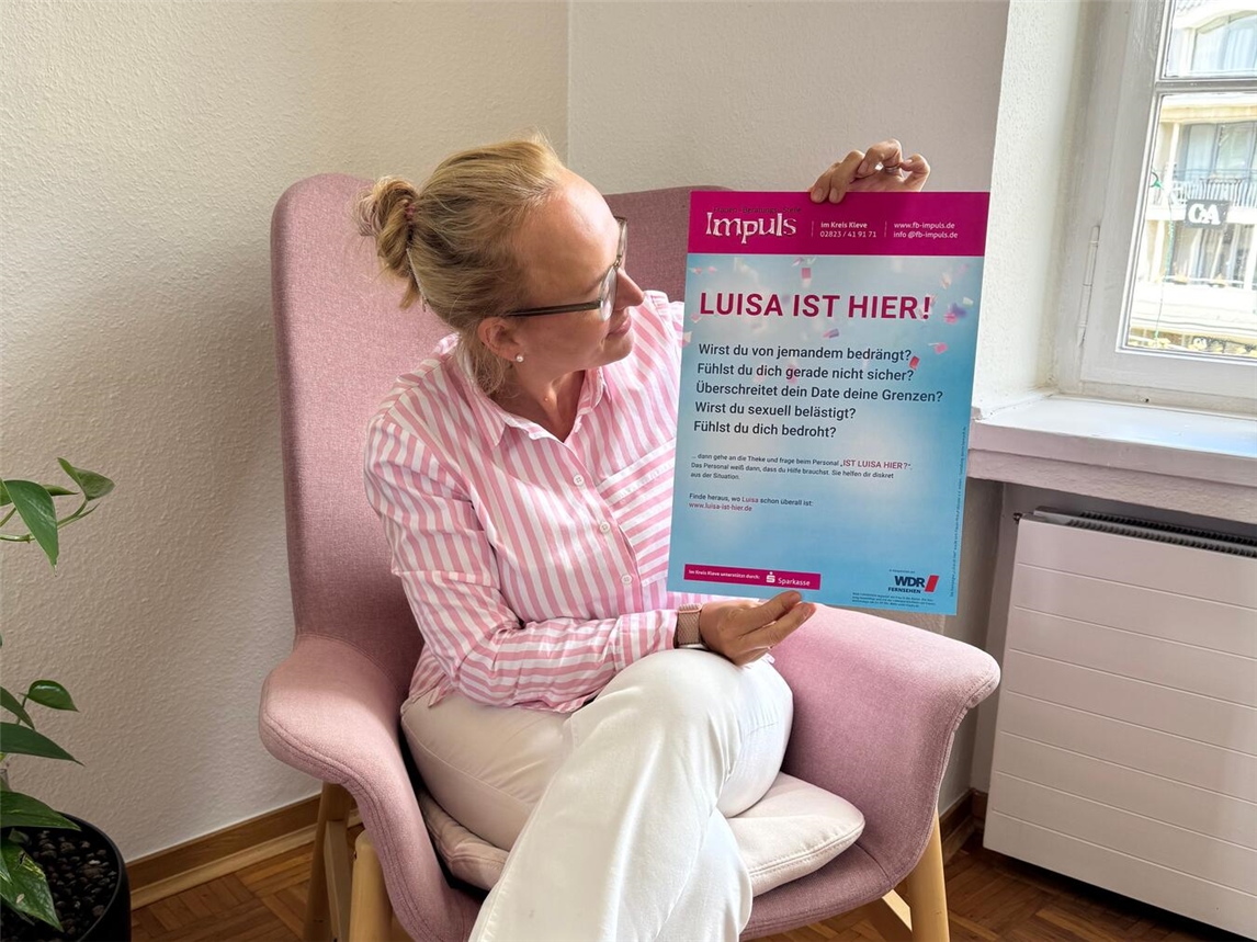 "Geschäftsführerin Jennifer Strücker präsentiert Plakat zur Stadtwerke-Initiative im Kundencenter und Verwaltungsgebäude"