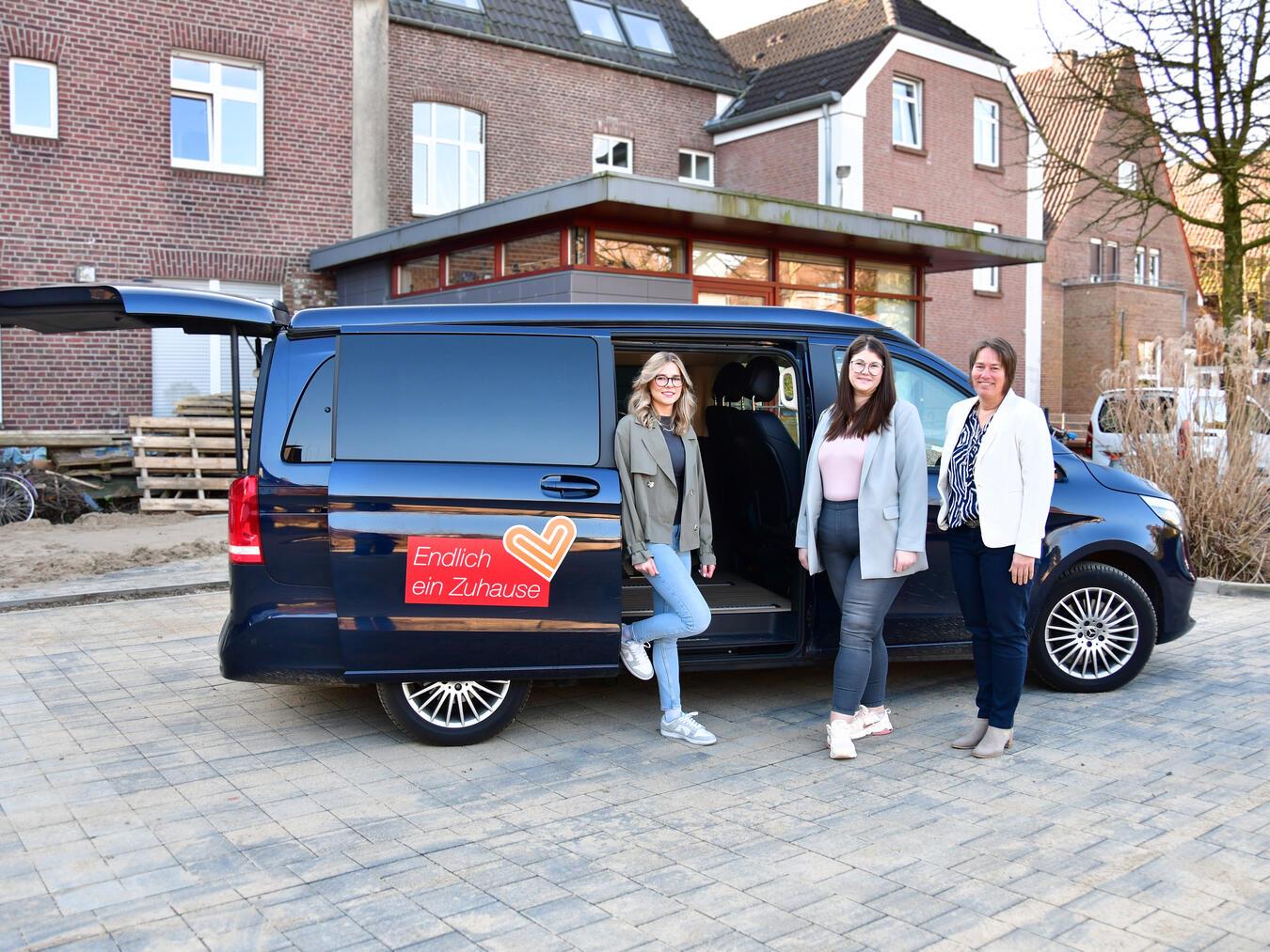 Staffelübergabe auf dem Hof der Klever Caritas: Seit dem 1. März steuern Hannah und Lisa Jörissen den mobilen Beratungsbus im nördlichen Kreis Kleve. Fachbereichsleiterin Rita Fergen freut sich, dass das Kümmerer-Projekt bis Ende 2027 fortgeführt wird. Foto: Caritas Kleve