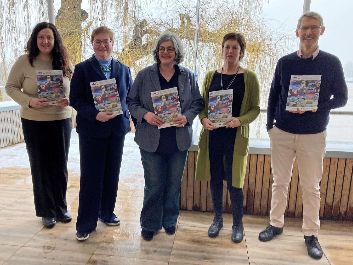 Stellen das neue VHS-Programm für das erste Semester 2025 in Rees und Emmerich vor: (v. l.) Aija Samina-Edelhoff (VHS), Sigrid Mölleken (Stadt Rees), Andrea Joosten (Stadt Emmerich), Susanne Hoos (Stadt Rees) und Alf-Thorsten Hausmann (VHS). Foto: Stadt Rees