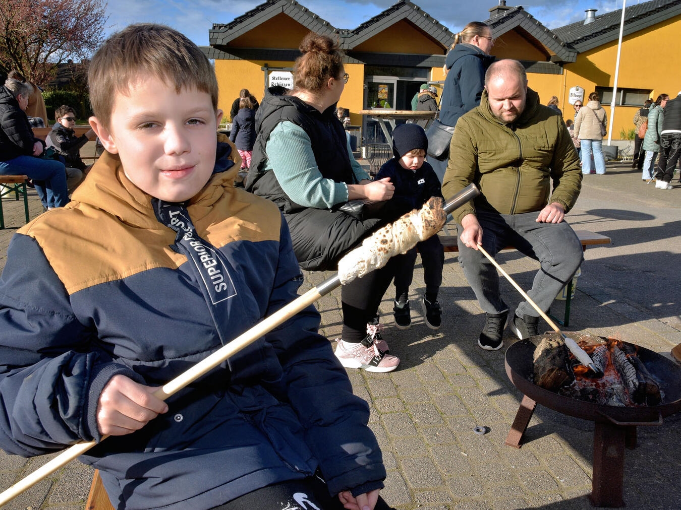 Kinder backen Stockbrot am Osterfeuer des Bürgerschützenvereins Kellen.