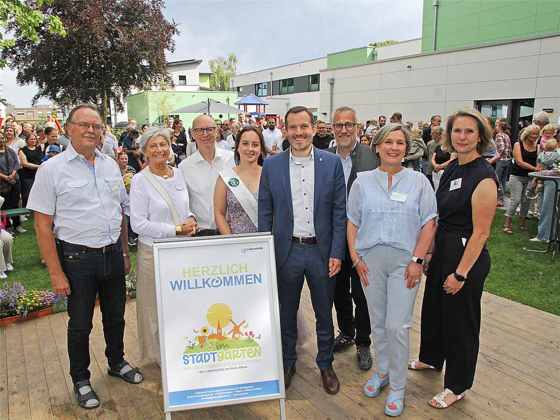 Straelens Bürgermeister Bernd Kuse (4.v.r.) freute sich mit dem Team der Lebenshilfe im Kreis Kleve über die Einweihung der neuen Kindertageseinrichtung Im Stadtgarten: (v.l.) Friedhelm Bucksteeg (Aufsichtsratsvorsitzender), Adelheid Ackermann (stellvertretende Aufsichtsratsvorsitzende), Jörg Kador (Vorstand), Straelens Blumenmädchen Anna Heekeren, Stephan R. Brockschmidt (Vorstand), Andrea Weyers (Fachbereichsleiterin) und Bianca Verbraeken-Pohland (KiTa-Leiterin).NN-Fotos: Theo Leie