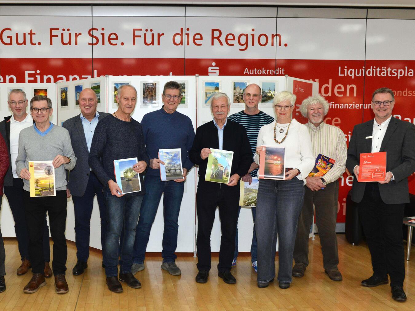 Sparkassen-Wandkalender 2025 ist ab sofort erhältlich Thomas Müller (3. v. l.) und Uwe Merling (r., beide von der Sparkasse) mit den Fotografen. Foto: Klaus-Dieter Stade