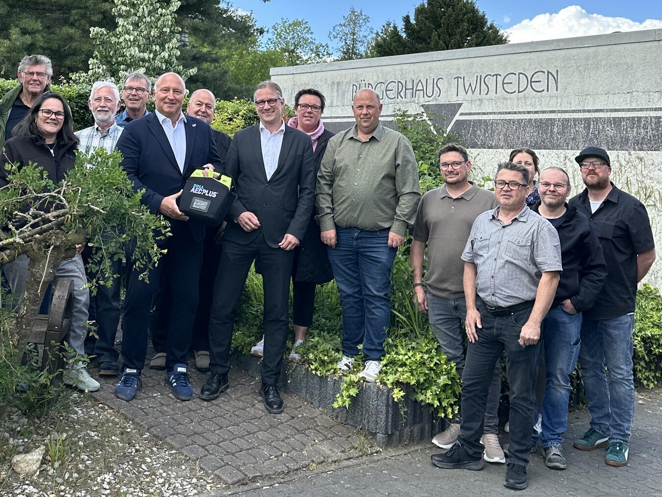 Thomas Müller, Mitglied des Vorstands der Sparkasse Rhein-Maas, überreicht die Defibrillatoren symbolisch an Bürgermeister Dr. Dominik Pichler sowie an die Vertretungen der jeweiligen Betreibervereine. Foto: Wallfahrtsstadt Kevelaer