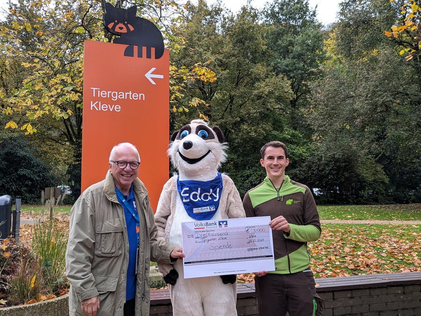 Tiergartenleiter Martin Polotzek und Volksbank-Botschafter Theo Brauer mit Maskottchen Eddy und einer Spende für den Familienzoo. Foto: Tiergarten Kleve