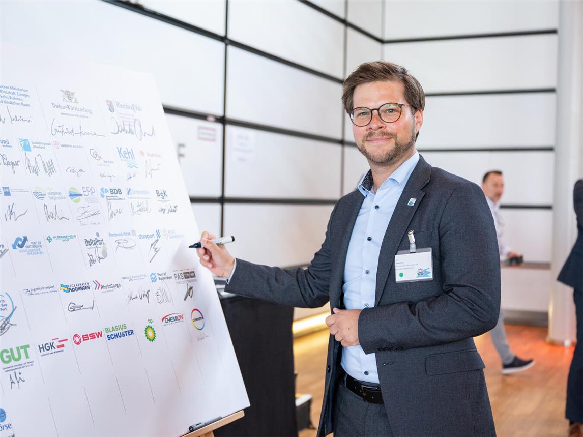 Tobias Mies, Geschäftsführer der Port Emmerich Infrastruktur- und Immobiliengesellschaft, unterschreibt die Absichtserklärung „Perspektive nachhaltige Rheinschifffahrt 2030“. Foto: Land NRW/Mark Hermenau