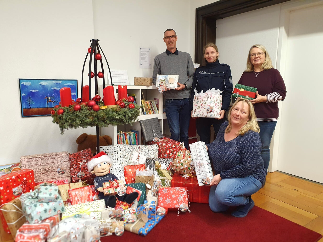 Tobias Neifeind (links) nimmt gemeinsam mit seinen Kolleginnen Sonja Albers und Anja Merling die Geschenkespenden vom Zoll entgegen. Foto: Caritas