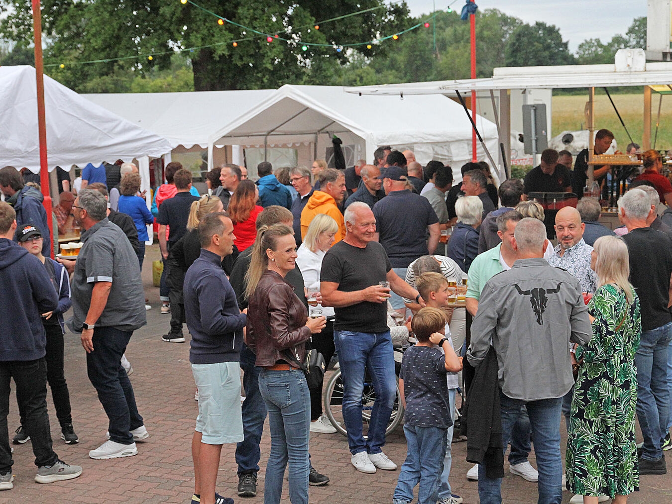 "Traditionelles Hamber Dorf- und Feuerwehrfest, lebhafte Szene mit Besuchern und Feuerwehraktivitäten"