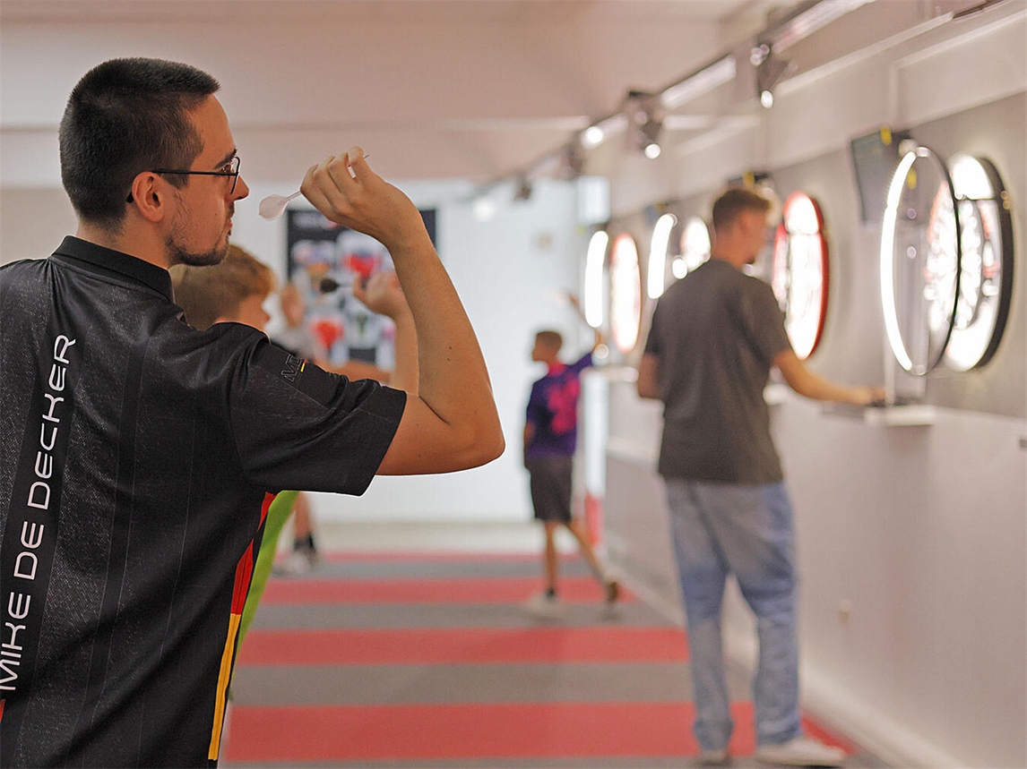 "Training in der Gelderner Dart-Arena, Spieler beim Zielen auf Dartscheibe, NN-Foto von Theo Leie"
