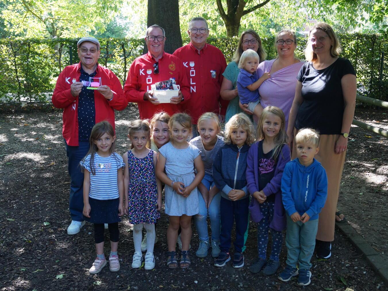 Über den Zuschuss zur neuen Schaukel freuten sich vlnr. Hans Kubon, Jochen Lichte und Gerd Lange von de kölsche Tön, Nicole Kroschewski und Anouschka Gausmann vom Förderverein und die Leiterin Raphaela Schmetter. Auf den Korb mit veganen Süßigkeiten spekulierten sowohl die Kinder als auch das Kindergartenpersonal. Foto: Hans Kubon