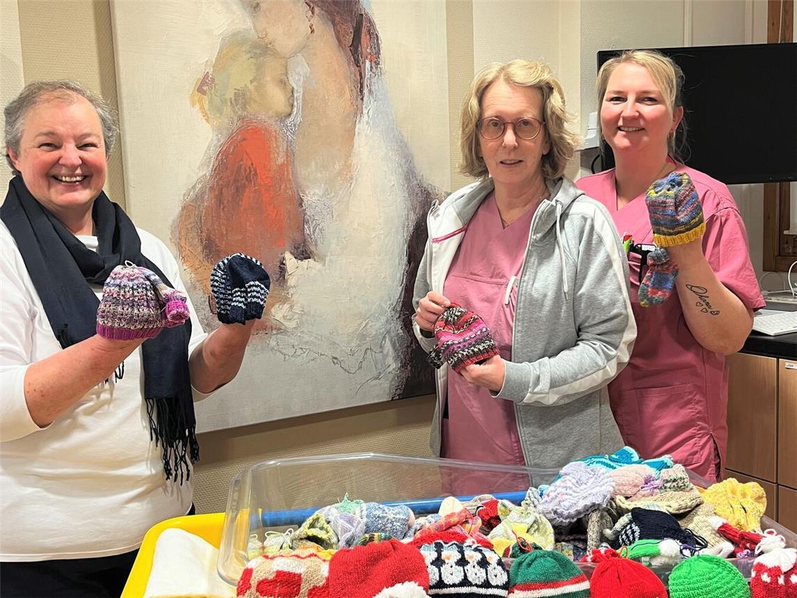 Ulrike Heetlage (l.) von der Initiative Zwergenglück aus Kleve übergibt bunte Mützchen und Söckchen an Dr. med. Ute Janßen, Chefärztin der Klinik für Gynäkologie und Geburtshilfe, und Stationssekretärin Marcellina Niewerth im Kreißsaal des St.-Clemens-Hospitals.Foto: St.-Clemens-Hospital