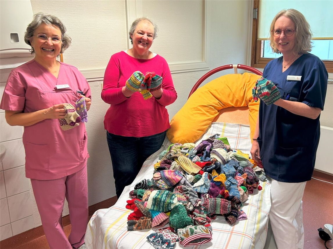 Ulrike Heetlage (m.) von der Initiative Zwergenglück aus Kleve übergibt bunte Mützchen und Söckchen an Dr. med. Ute Janßen, Chefärztin der Klinik für Gynäkologie und Geburtshilfe, und Sabine Toennessen, leitende Hebamme im Kreißsaal des St.-Clemens-Hospitals.Foto: St.-Clemens-Hospital