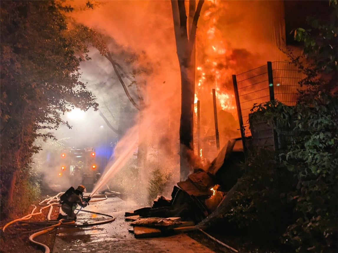 "Feuerwehr Kleve bekämpft Großbrand mit mehreren Schläuchen im Einsatz, um Flammen unter Kontrolle zu bringen."