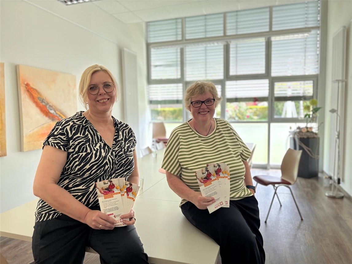 Ursula Kertelge (r., Leiterin der Familienbildungsstätte in Kalkar) und Elke Huber- Groenewald (Leiterin der Mobilen Pflege in Kalkar) mit den Flyern zum Kursus für pflegende Angehörige. Foto: Caritas