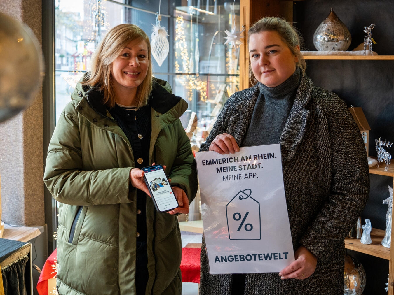 Verena van Niersen (l.) und Hannah Pohl von der Emmericher WfG stellen die neue Funktion in der Emmerich-App vor. Foto: WfG Emmerich