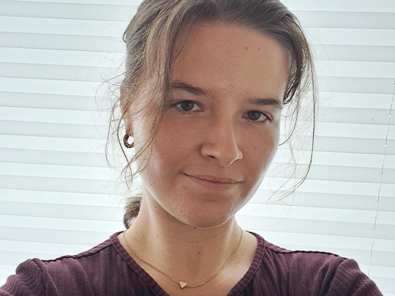 "Vivian Menne, 25, Autorin und Illustratorin, lächelnd im Atelier, umgeben von Zeichnungen und Büchern"