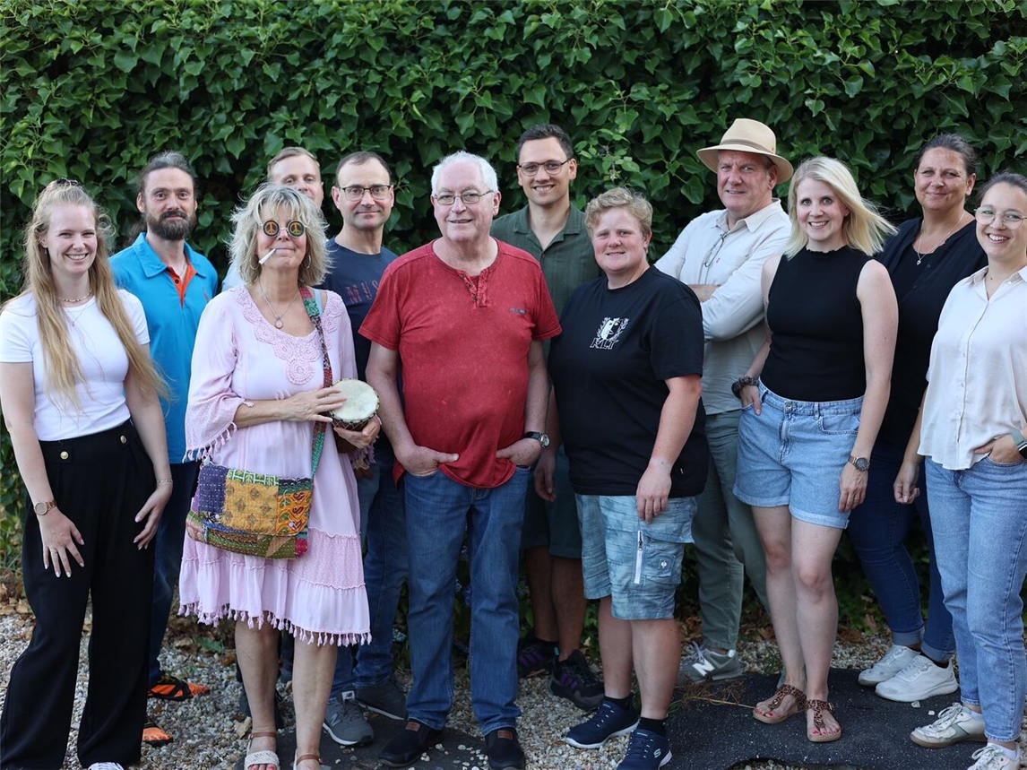 Gruppenfoto von zwölf Personen, einschließlich Isabell Richter und Frank Pooth, lächelnd in formeller Kleidung.