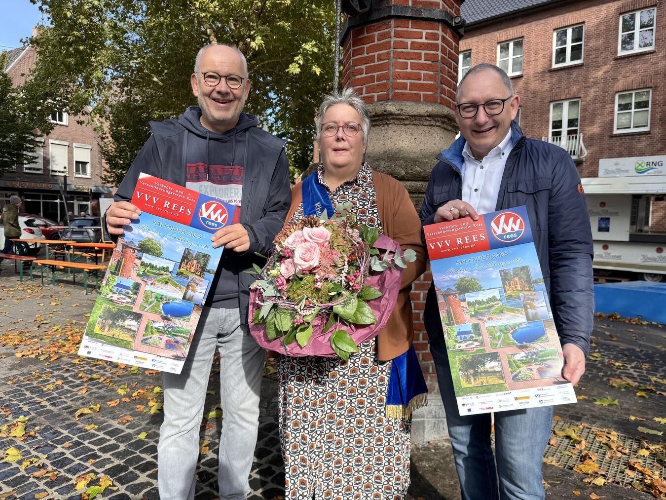 Vorsitzender Bernd Hübner überreicht Rheinkönigin Jutta Green und Bürgermeister Sebastian Hense (v. l.) ihre Exemplare des neuen VVV-Kalenders. Foto: VVV Rees