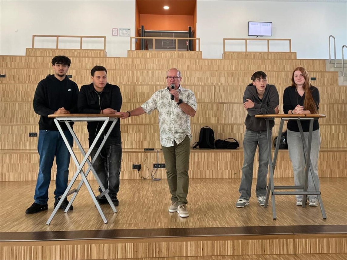 Während der Podiumsdiskussion im Forum stellten sich Sajad, Aimen, Chris und Nora (v.l.) den Fragen der S Schüler. Moderiert wurde die Veranstaltung von Schulleiter Wilfried Schönherr (Mitte).Foto: privat
