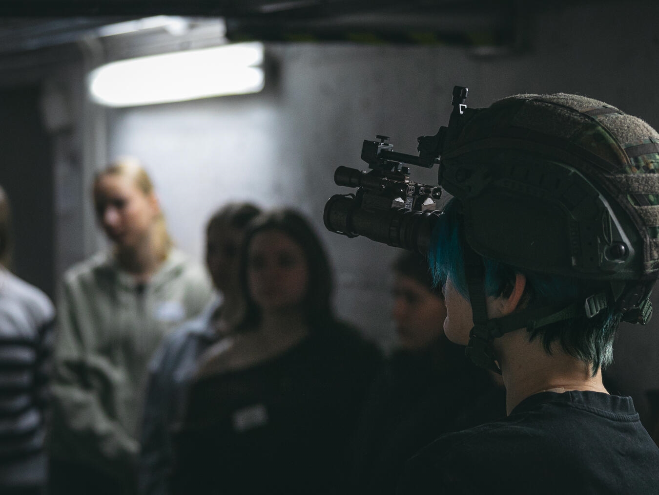 Während eine Teilnehmerin das Nachtsichtgerät testet, verfolgt die Gruppe gespannt den Einsatz im Dunkeln. Foto: Patrick Bransmöller