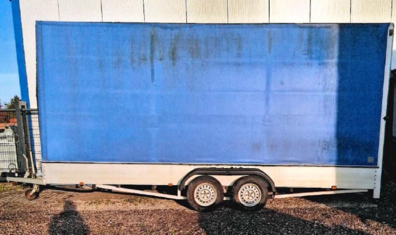 Alt-Tag: "Nahaufnahme eines goldenen Anhängers auf Holztisch, verloren und unidentifiziert, Schmuckstück"