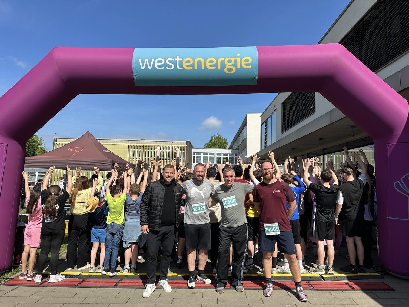 Westenergie-Kommunalmanager Nils Rudolph, Xantens Bürgermeister Rafael Zur, Schulleiter Jörg Bröscher und Sportlehrer Lucas Merani (vorne v.l.)geben den Startschuss für das Westenergie Distanz Duell an der Willi-Fährmann-Gesamtschule in Xanten. Foto: Westenergie