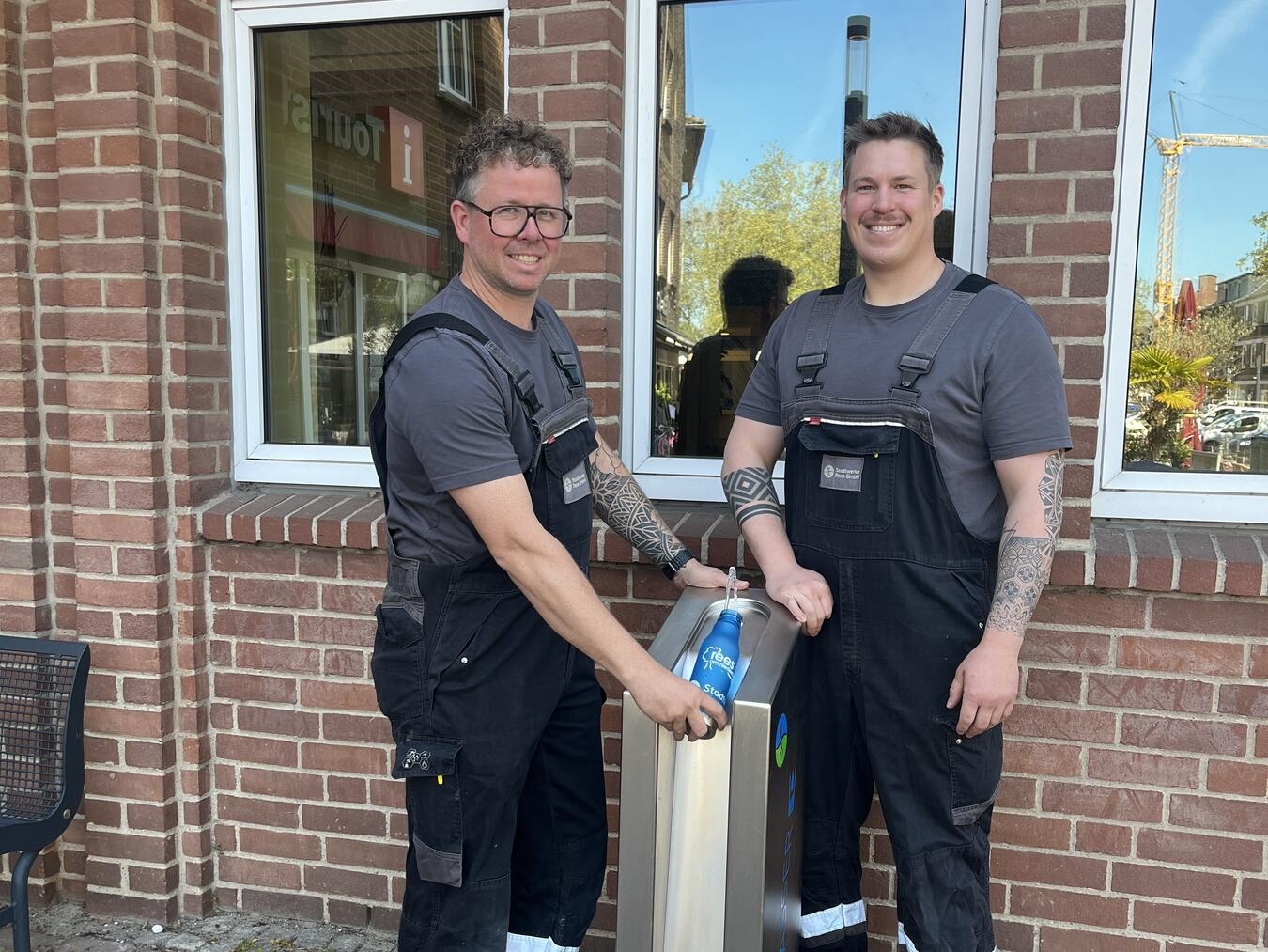 "Inbetriebnahme Wasserspender vorm Reeser Rathaus durch SW-Rees-Mitarbeiter im April; Vorbereitung auf Sommersaison."