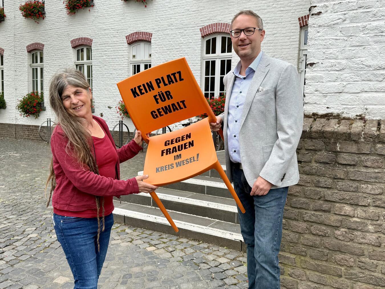 Xantens Gleichstellungsbeauftragte Sabine Reuß hat den orangefarbenen Stuhl an Jochen Cleve vom APX übergeben. Im August wird er am dortigen Amphitheater ebenfalls auf das Thema Gewalt gegen Frauen aufmerksam machen. NN-Foto: SP