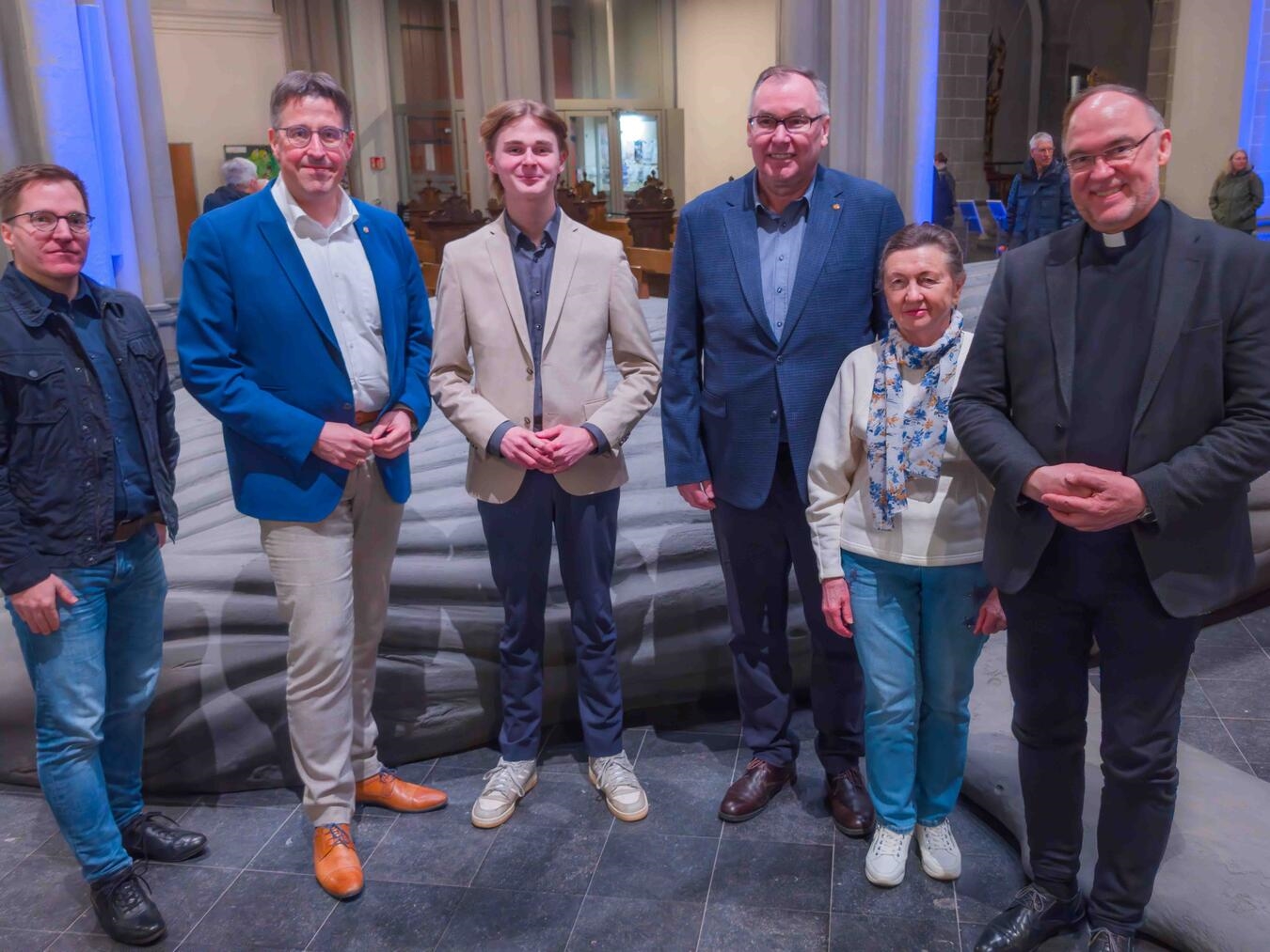 Zum Gruppenbild am Wal trafen sich nach der Podiumsdiskussion (v.l.) Jürgen Flatken, René Schneider, Lukas Potthoff, Anatolii Bugarev mit seiner Dolmetscherin und Rolf Lohmann. Foto: Bischöfliche Pressestelle/Christian Breuer