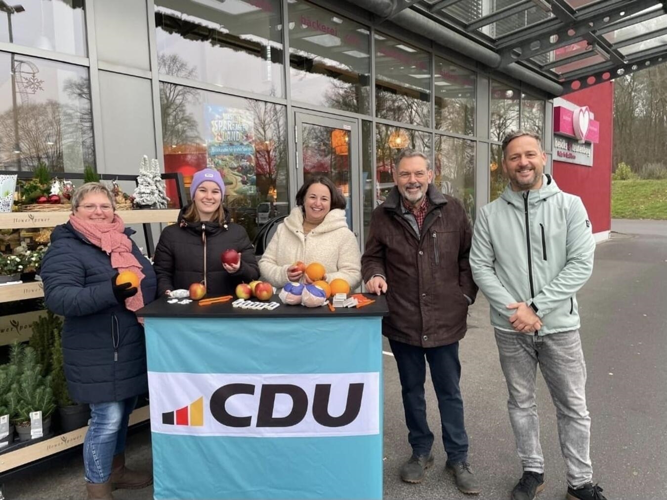 Zur Verteilung von Äpfeln und Apfelsinen an interessierte Bürger während der Weihnachtsaktion des CDU-Gemeindeverbandes Bedburg-Hau trafen sich vor einem Geschäft in Schneppenbaum (v.l.):  Astrid Kurek, die Vorsitzende Jule Linkner, Anna-Kristin Seifert, Lothar Winkels und Nico Moede. Foto: CDU Bedburg-Hau